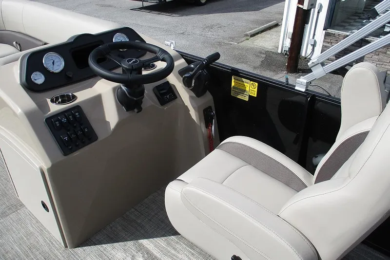 Slide: The Image of 2026 Bentley Pontoons LE 180 CR interior with steering wheel and beige seating. - 22