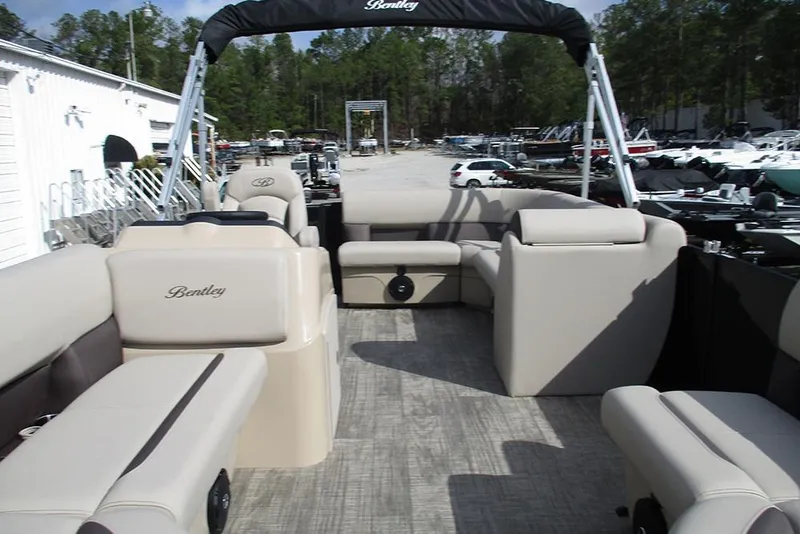 Slide: The Image of 2026 Bentley Pontoons LE 180 CR interior with beige seating and open deck layout. - 9