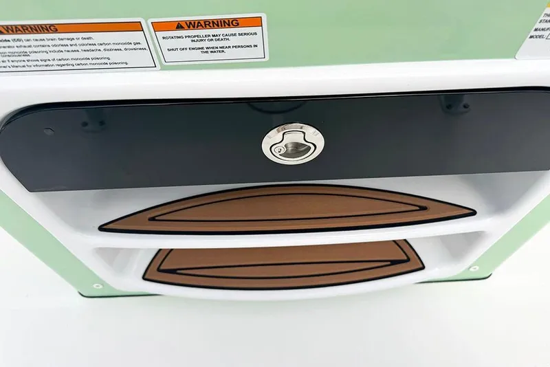 Slide: The Image of 2026 Sea Pro 230 Bay boat storage compartment with warning labels and secure lock. - 32