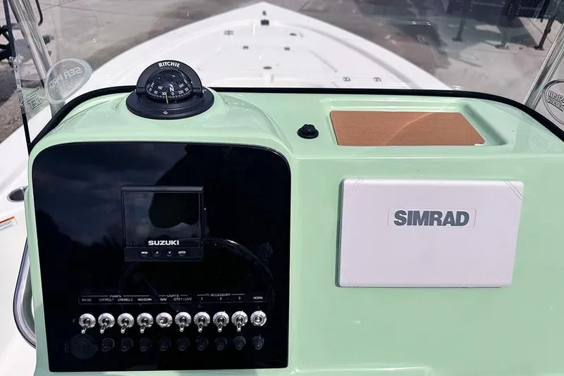 Slide: The Image of 2026 Sea Pro 230 Bay boat dashboard with Suzuki controls and Simrad navigation system. - 36