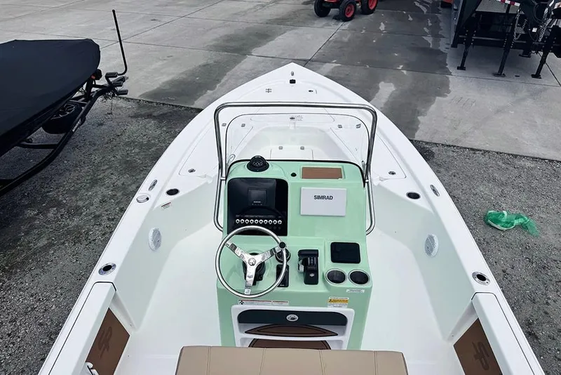 Slide: The Image of 2026 Sea Pro 230 Bay boat with modern console and steering wheel, docked on concrete. - 47