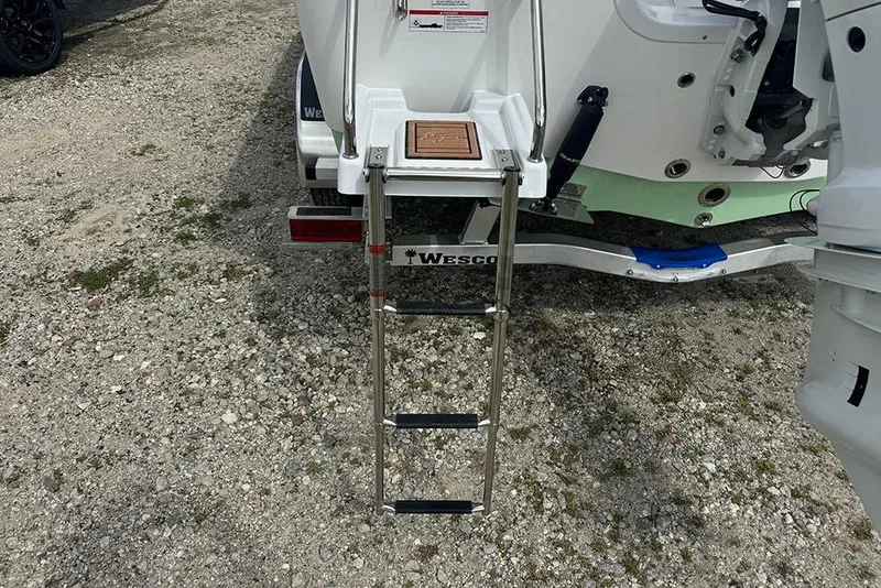 Slide: The Image of 2026 Sea Pro 230 Bay boat with ladder on Wesco trailer, parked on gravel. - 5