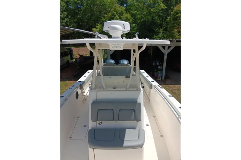 Slide: The Image of 2014 Cobia 296 Center Console boat with seating and canopy, docked outdoors. - 14