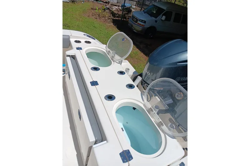 Slide: The Image of 2014 Cobia 296 Center Console boat with open livewells and Yamaha outboard engine. - 16