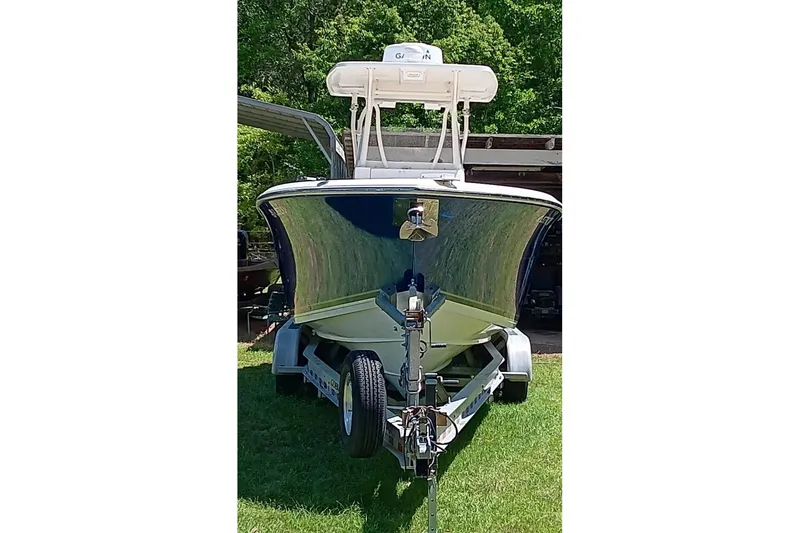 Slide: The Image of 2014 Cobia 296 Center Console boat on trailer, parked on grass. - 23
