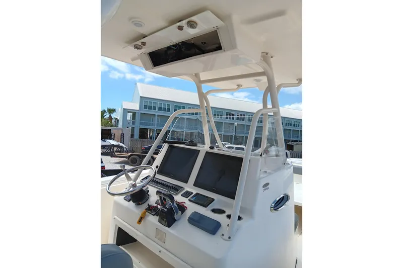 Slide: The Image of 2014 Cobia 296 Center Console boat dashboard with steering wheel and navigation screens. - 26