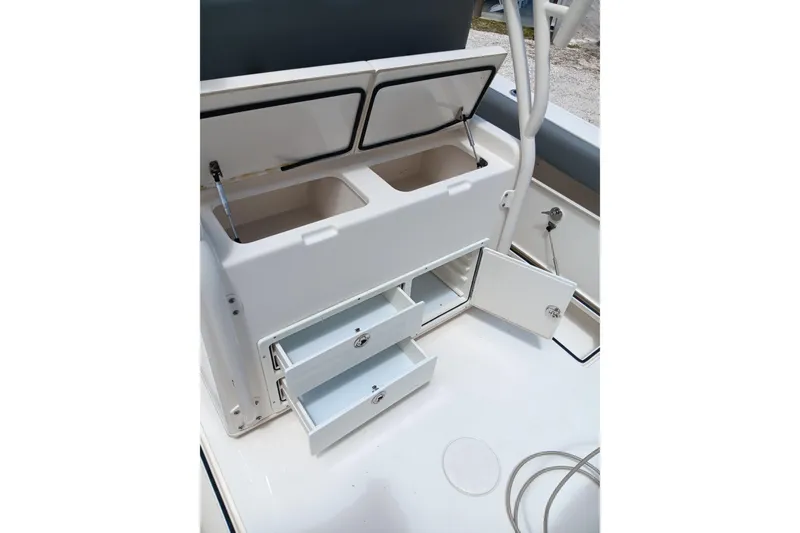 Slide: The Image of 2014 Cobia 296 Center Console boat storage compartments with open drawers and lids. - 27