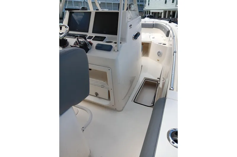 Slide: The Image of 2014 Cobia 296 Center Console boat interior with helm and seating area. - 28