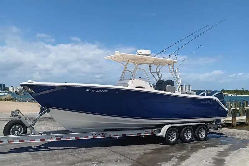 Slide: The Image of 2014 Cobia 296 Center Console boat on trailer by the waterfront. - 29