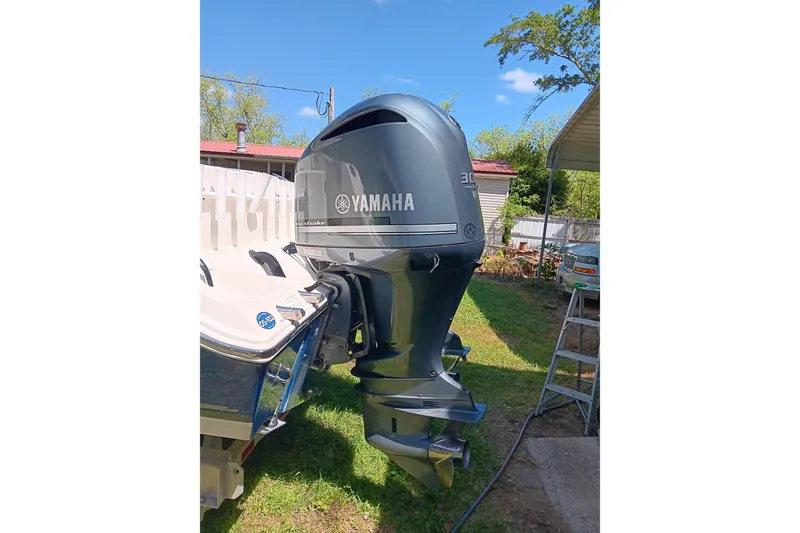 Slide: The Image of 2014 Cobia 296 Center Console with Yamaha outboard motor in a backyard setting. - 3