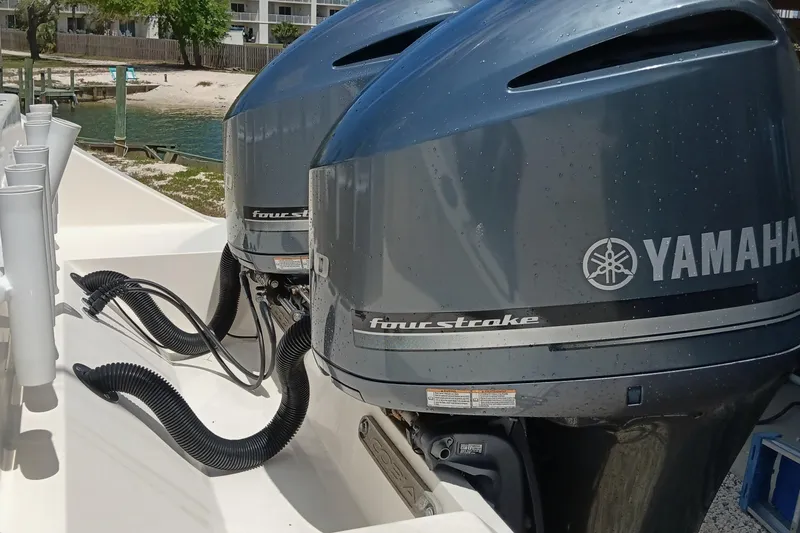 Slide: The Image of 2014 Cobia 296 Center Console with Yamaha four-stroke engines, docked near shoreline. - 30