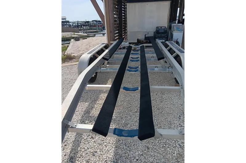 Slide: The Image of Boat trailer for 2014 Cobia 296 Center Console on gravel surface. - 36