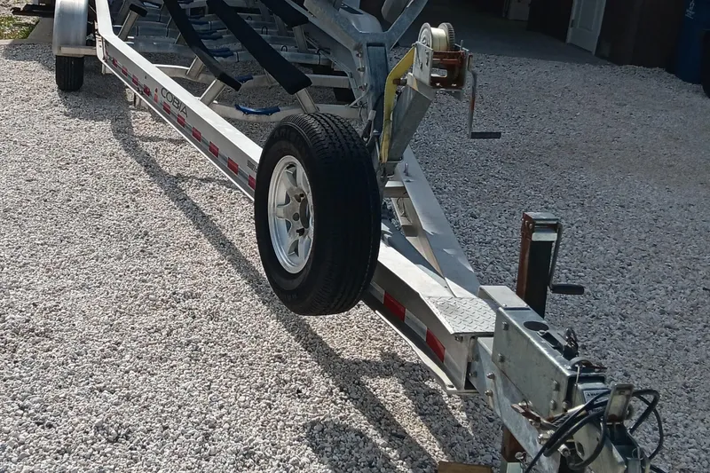 Slide: The Image of Trailer for 2014 Cobia 296 Center Console boat on gravel surface. - 39