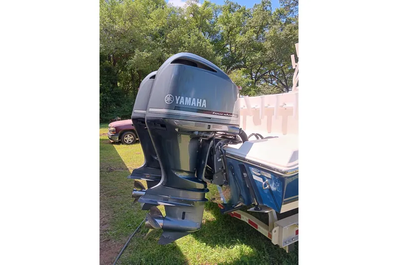 Slide: The Image of 2014 Cobia 296 Center Console with Yamaha outboard motor in a grassy area. - 4