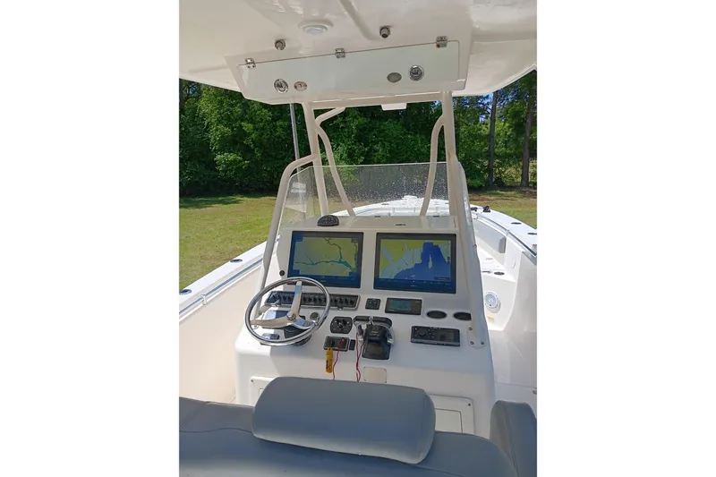 Slide: The Image of 2014 Cobia 296 Center Console boat dashboard with navigation screens and steering wheel. - 7