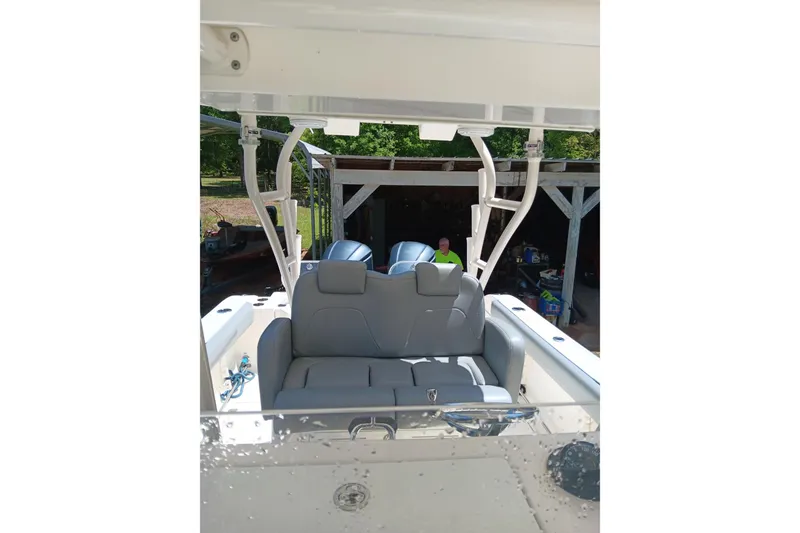 Slide: The Image of 2014 Cobia 296 Center Console boat with seating and dual engines in a sunny outdoor setting. - 8