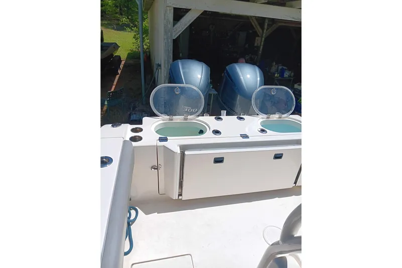 Slide: The Image of 2014 Cobia 296 Center Console boat with dual outboard engines and open storage compartments. - 9