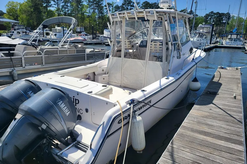 Slide: The Image of 2004 Grady-White Marlin 300 boat docked with Yamaha engines, marina background. - 2