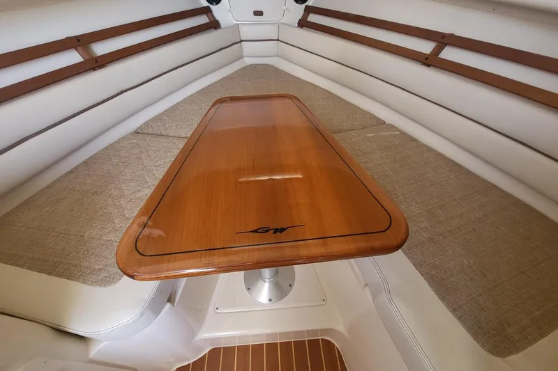 Slide: The Image of Interior of 2004 Grady-White Marlin 300 boat with wooden table and cushioned seating. - 23