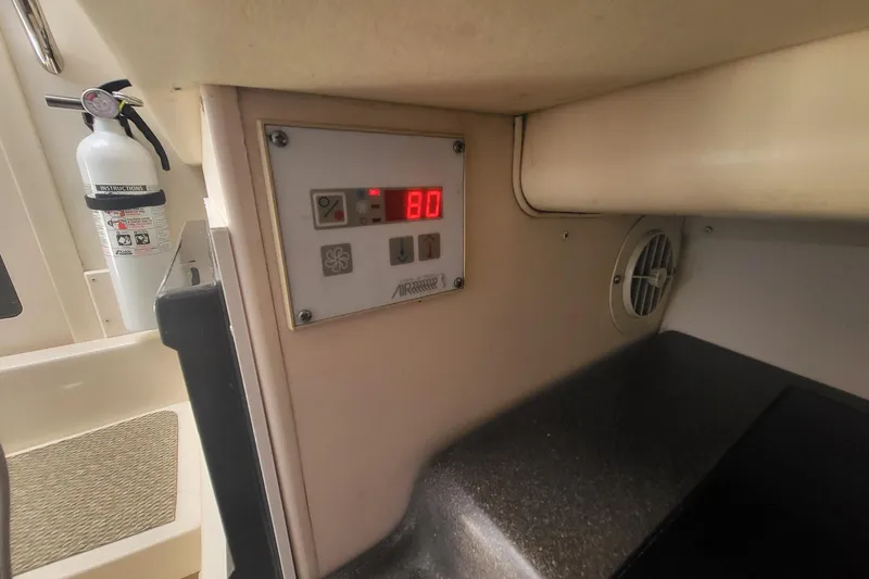 Slide: The Image of Control panel and fire extinguisher inside a 2004 Grady-White Marlin 300 boat cabin. - 6