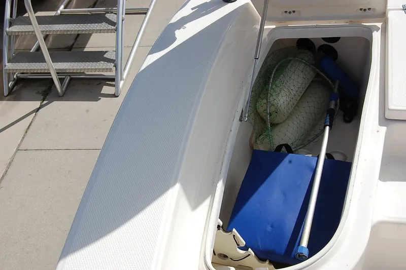 Slide: The Image of 2019 Robalo 226 Cayman boat storage compartment with fishing gear and accessories. - 17