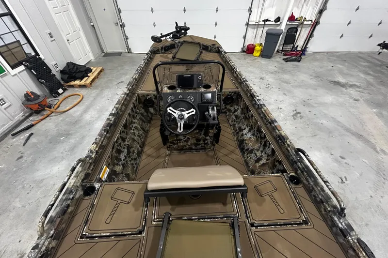 Slide: The Image of 2026 Thor Lake Hammer CC 1900 boat interior with camouflage design in a garage setting. - 10