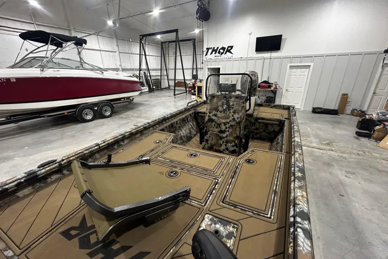 Slide: The Image of 2026 Thor Lake Hammer CC 1900 boat in showroom, featuring camouflage design and spacious interior. - 5