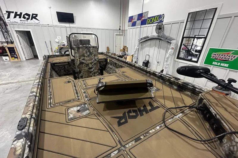 Slide: The Image of 2026 Thor Lake Hammer CC 1900 boat interior with camouflage design in a showroom. - 6