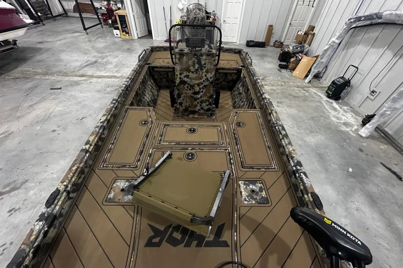 Slide: The Image of 2026 Thor Lake Hammer CC 1900 boat interior with camouflage design in a garage setting. - 9