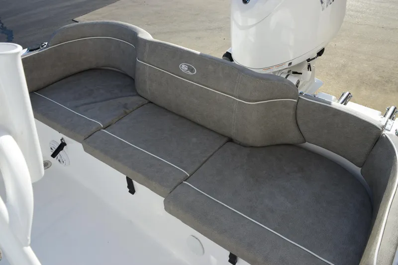Slide: The Image of 2026 Sea Hunt Ultra 219 boat with gray cushioned seating and white motor. - 9