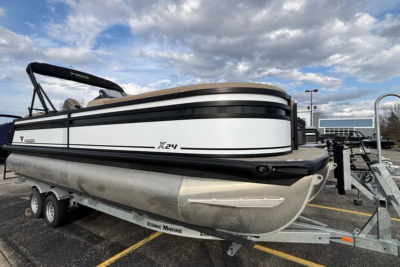 The Image of 2026 Viaggio Lago X24U pontoon boat on trailer under cloudy sky. - 1