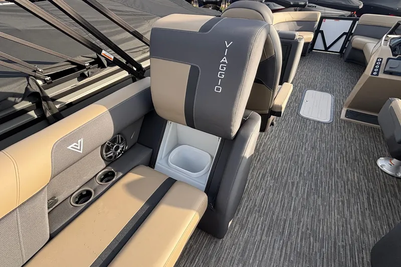Slide: The Image of 2026 Viaggio Lago X24U boat interior with beige and gray seating, cup holders, and speaker. - 14