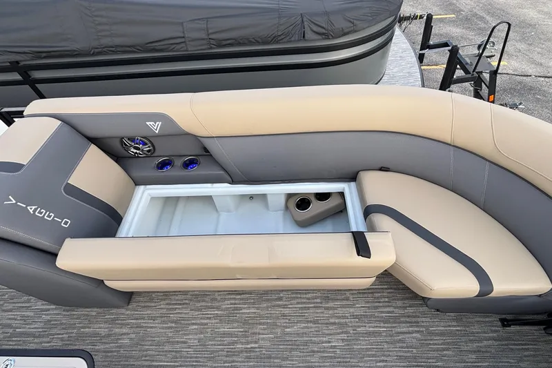 Slide: The Image of 2026 Viaggio Lago X24U boat interior with beige and gray seating, built-in storage, and cup holders. - 25