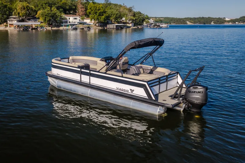 Slide: The Image of 2026 Viaggio Lago X24U pontoon boat on a serene lake with lush shoreline. - 5