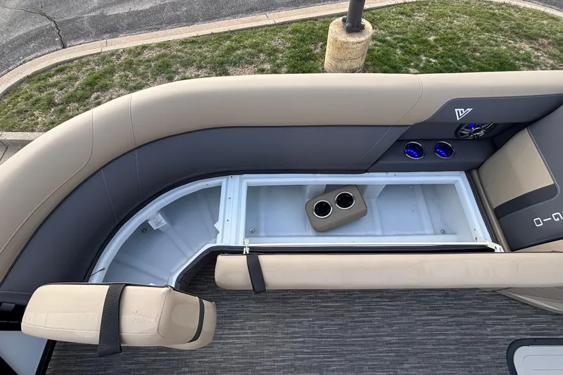 Slide: The Image of 2026 Viaggio Lago X24U boat interior with beige seating, cup holders, and storage compartment. - 27