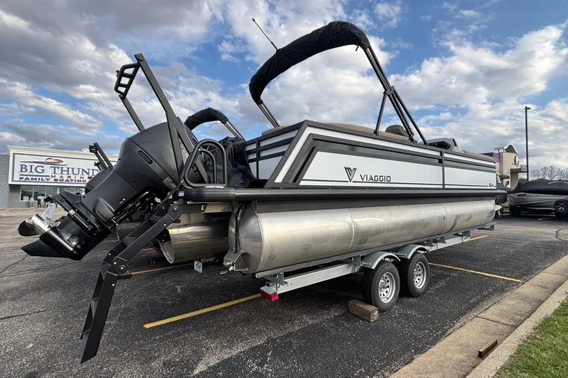 Slide: The Image of 2026 Viaggio Lago X24U pontoon boat on trailer, parked at marina. - 3