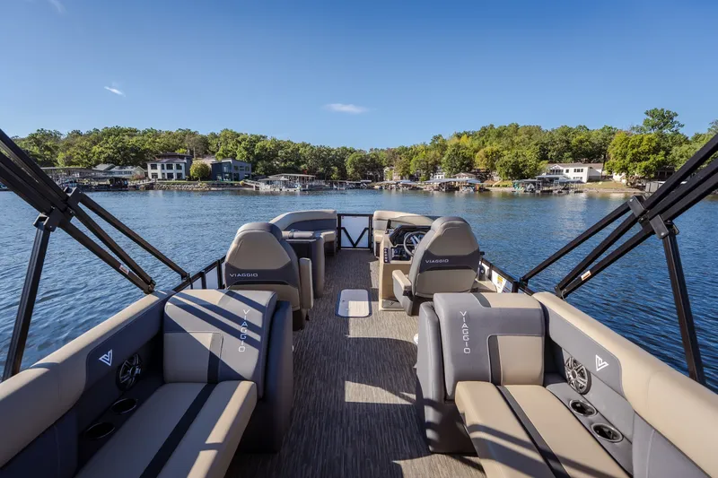 Slide: The Image of 2026 Viaggio Lago X24U pontoon boat on a serene lake with lush shoreline. - 40
