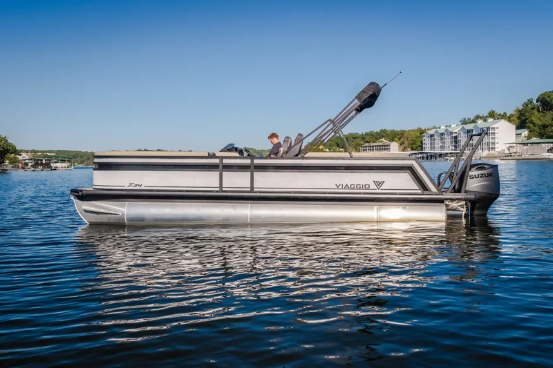 Slide: The Image of 2026 Viaggio Lago X24U pontoon boat on a serene lake with clear blue skies. - 4