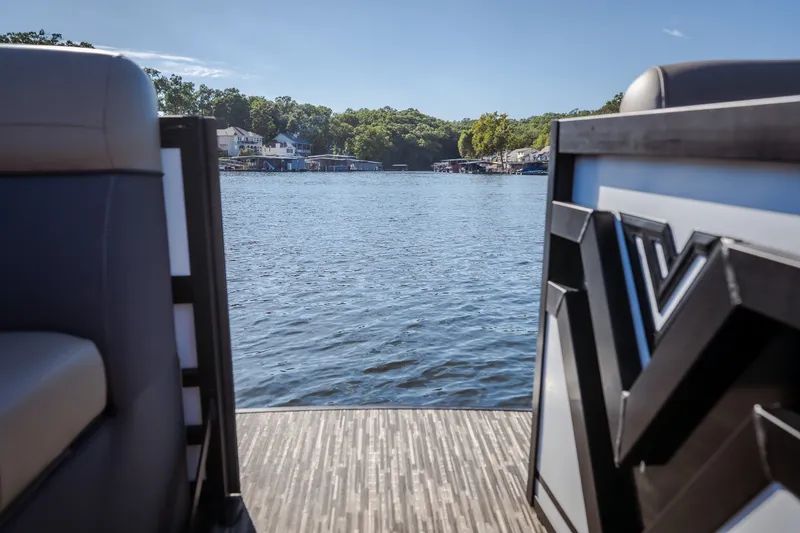 Slide: The Image of Viaggio Lago X24U 2026 pontoon boat on a serene lake with scenic shoreline. - 26
