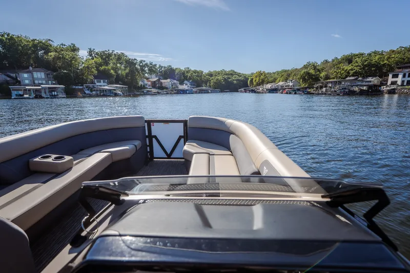 Slide: The Image of Viaggio Lago X24U 2026 pontoon boat cruising on a scenic lake with waterfront homes. - 20