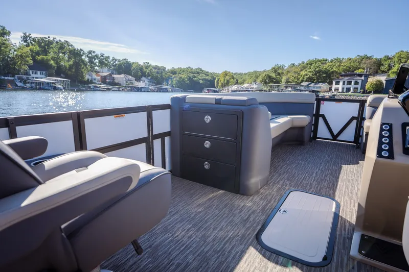 Slide: The Image of 2026 Viaggio Lago X24U pontoon boat interior with seating and storage, on a scenic lake. - 23