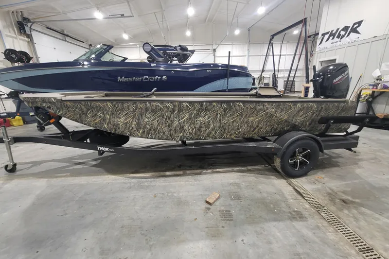 Slide: The Image of 2026 Thor 1860 Timber Hammer Elite boat with camouflage design in a showroom. - 4