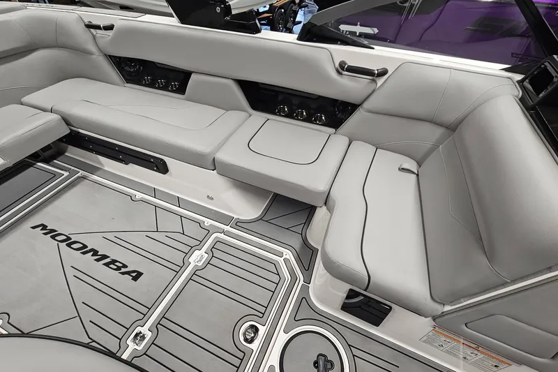 Slide: The Image of 2024 Moomba Mojo boat interior with gray seating and branded flooring. - 16