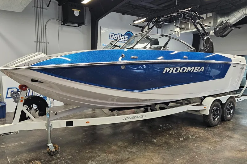 Slide: The Image of 2024 Moomba Mojo boat on trailer, blue and white design, displayed indoors. - 3