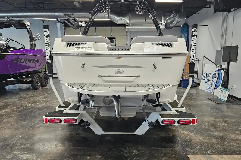 Slide: The Image of 2024 Moomba Mojo boat in showroom, rear view with swim platform and trailer. - 7