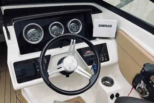 Slide: The Image of 2019 Sea Ray SPX 210 boat dashboard with steering wheel and Simrad navigation system. - 21