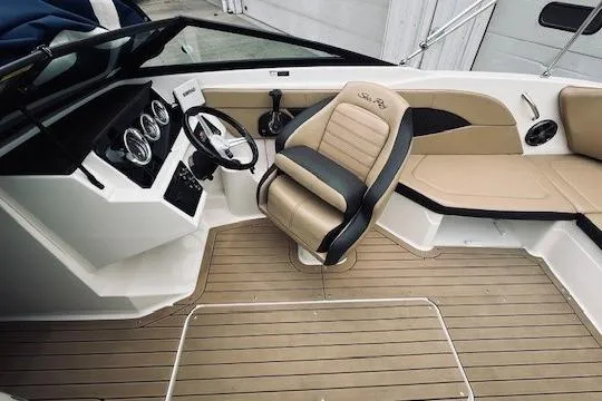 Slide: The Image of 2019 Sea Ray SPX 210 boat interior with beige seating and modern dashboard. - 5