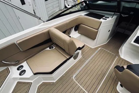 Slide: The Image of 2019 Sea Ray SPX 210 boat interior with beige seating and wood-style flooring. - 7