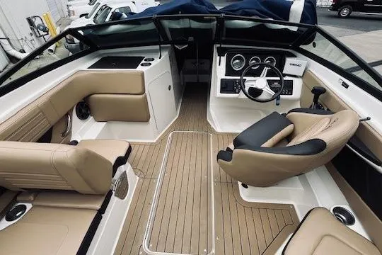Slide: The Image of 2019 Sea Ray SPX 210 boat interior with beige seating and modern dashboard. - 8