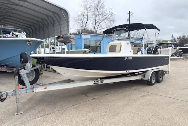 The Image of 2019 Tidewater 2410 Bay Max boat on trailer, parked outdoors near a blue building. - 0